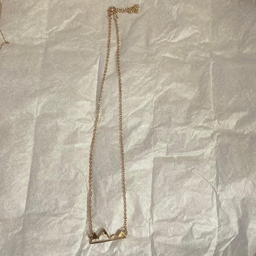 Gold necklace with mountain detail.